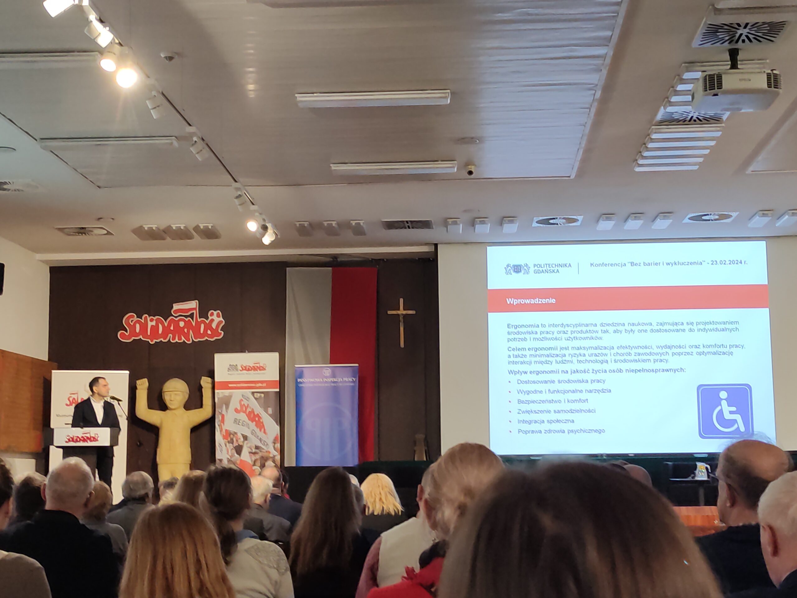 Zdjęcie z Konferencji. Widok na scenę wraz z rzutnikiem.