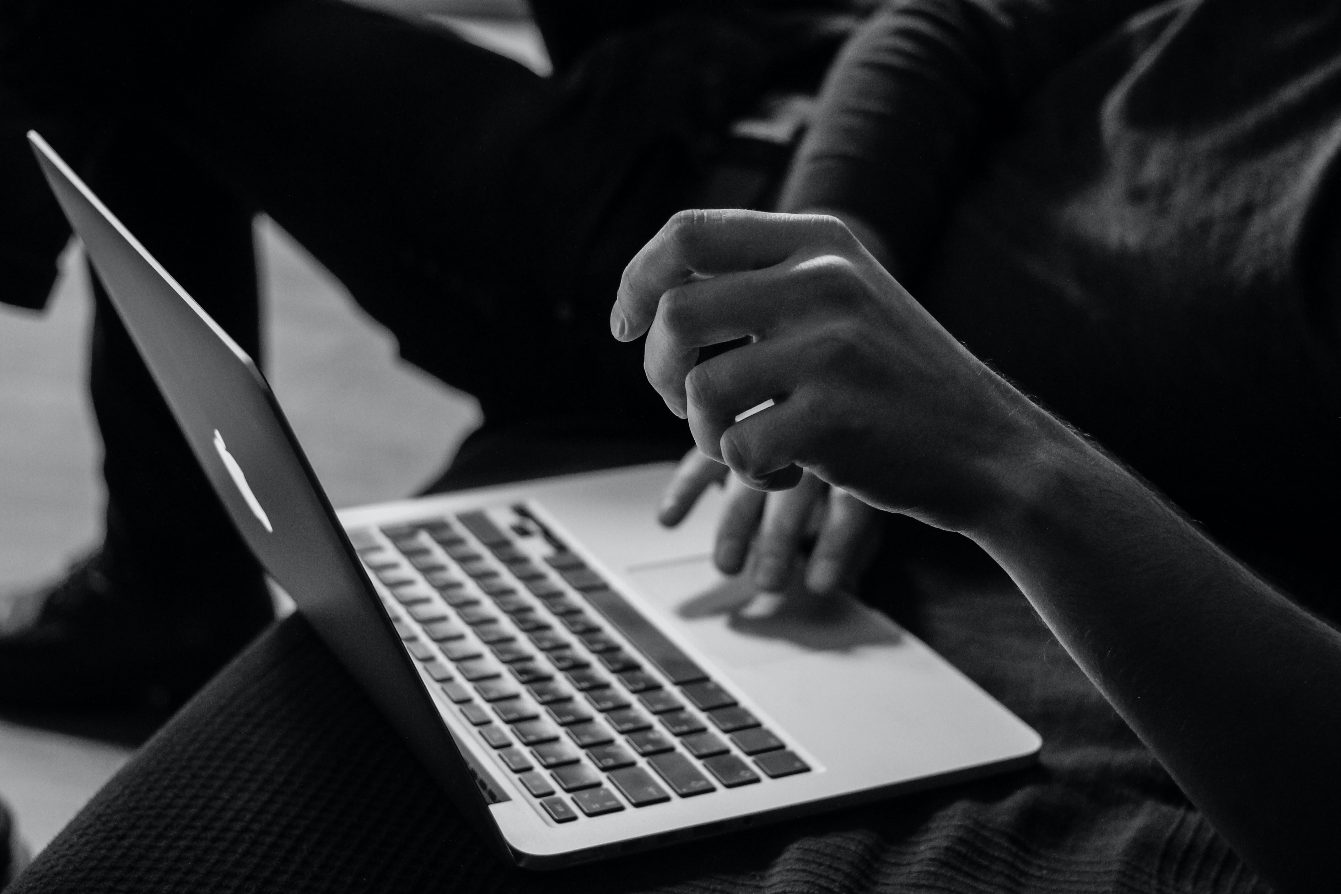 Na obrazku znajduje się laptop, który obsługuje pewna osoba.